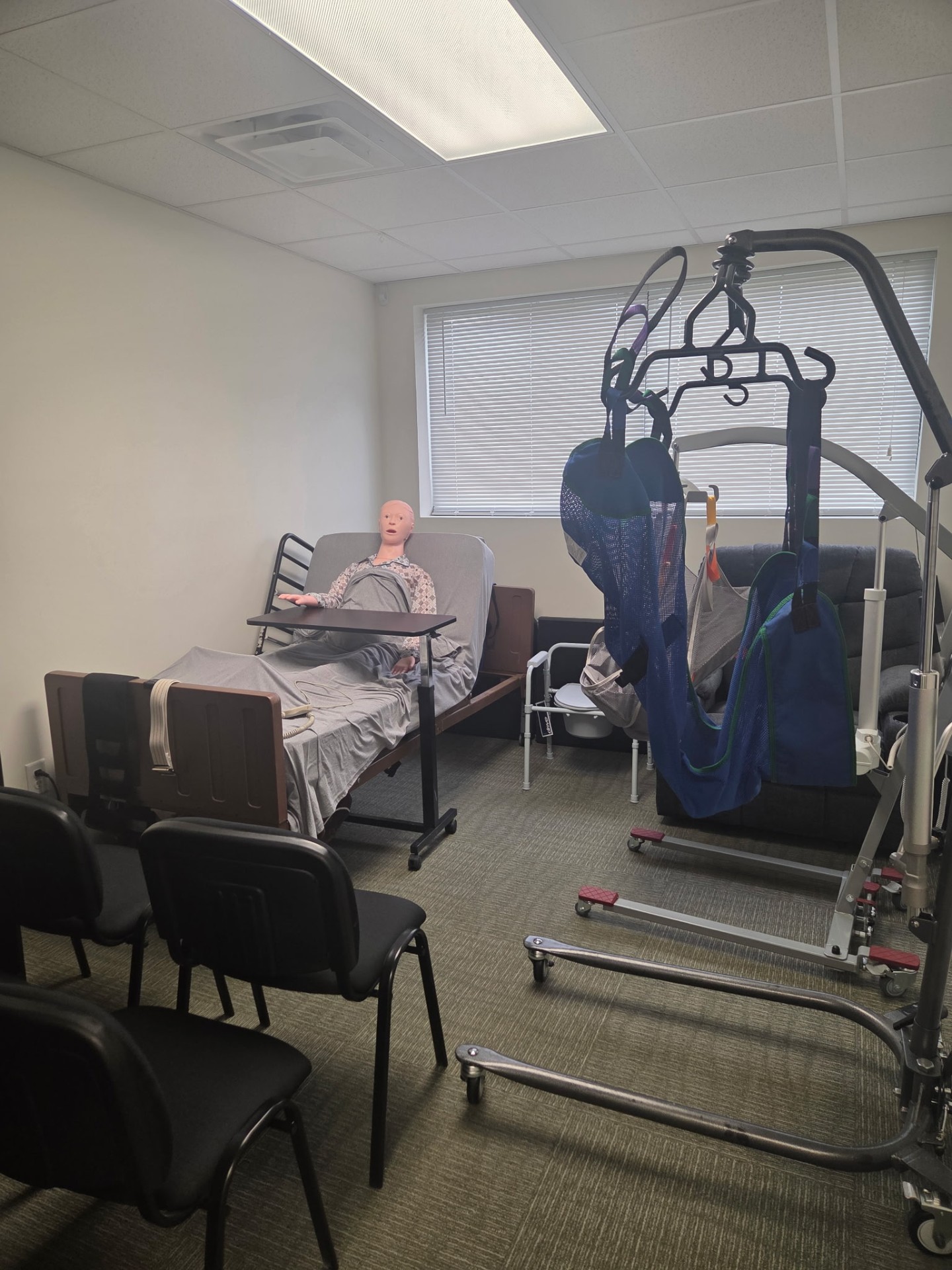 Above Best Care training room with hospital bed, patient lift equipment, and training mannequin